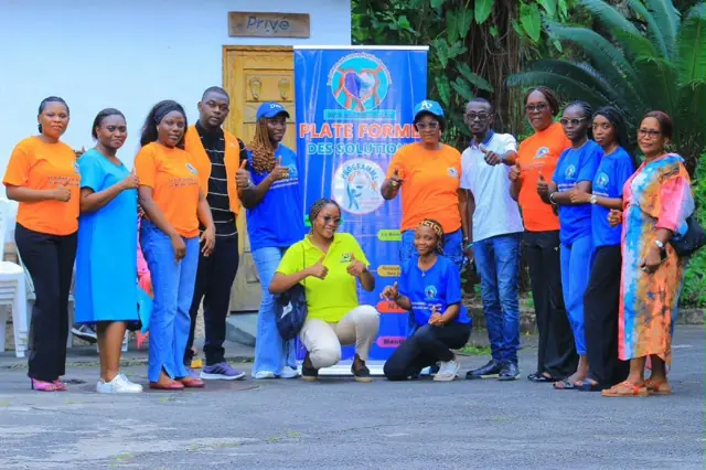 Photo de groupe joyeuse devant la bannière du programme